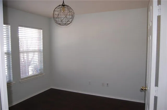 a room with a window and a chandelier fan