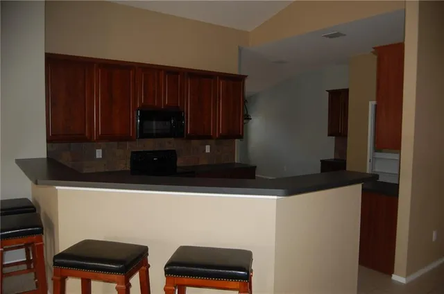 a kitchen with wooden cabinets and a microwave oven