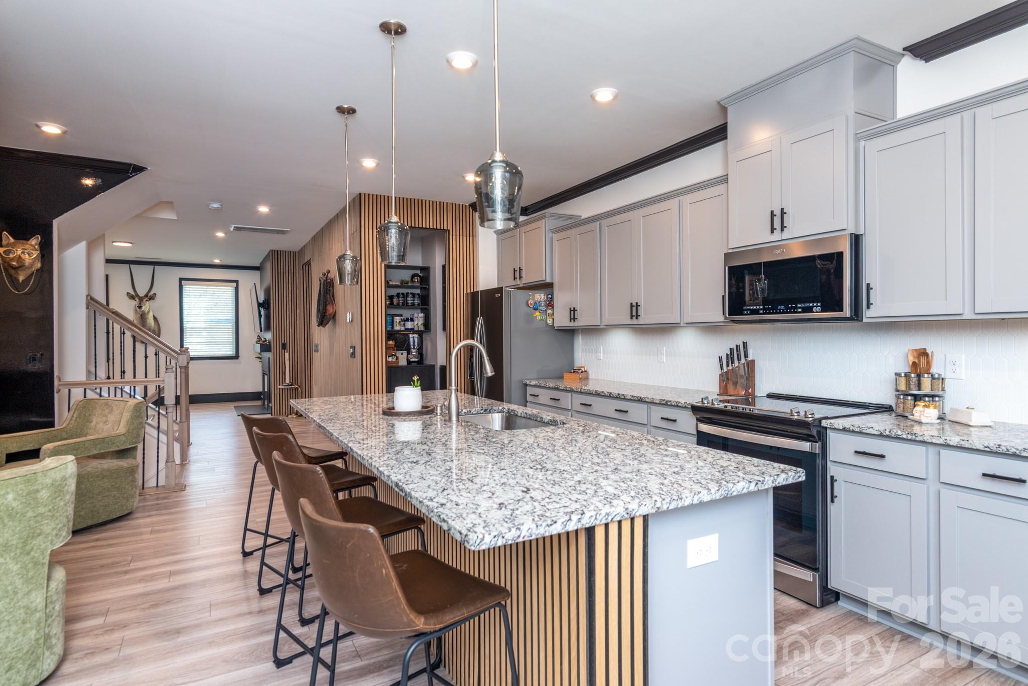 16629 Summers Walk Boulevard Davidson, NC 28036 - Photo 1 of 29 a kitchen with stainless steel appliances granite countertop a stove top oven a refrigerator a sink and a dining table with white cabinets