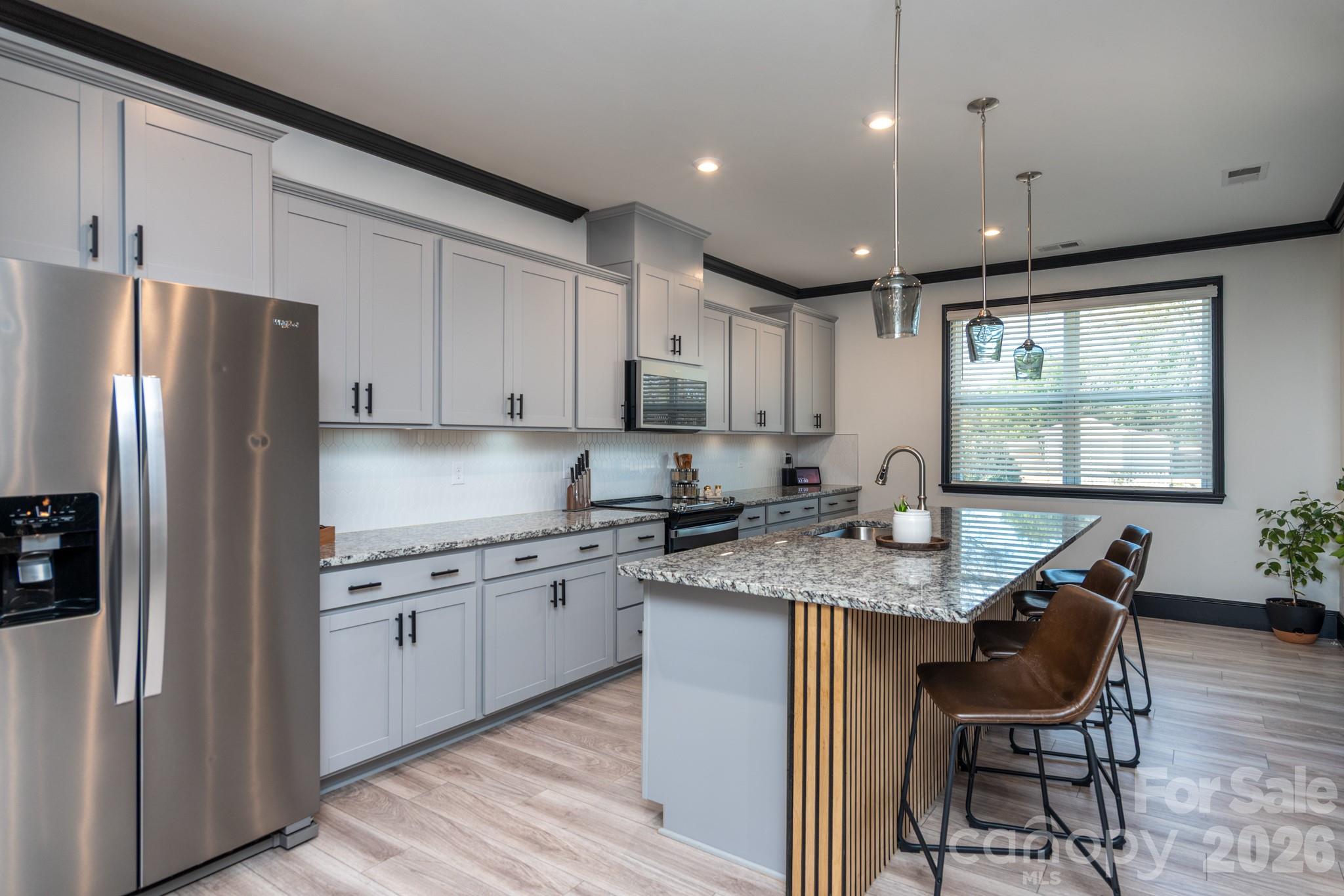16629 Summers Walk Boulevard Davidson, NC 28036 - Photo 3 of 29 a kitchen with stainless steel appliances granite countertop a stove refrigerator sink dining table and chairs