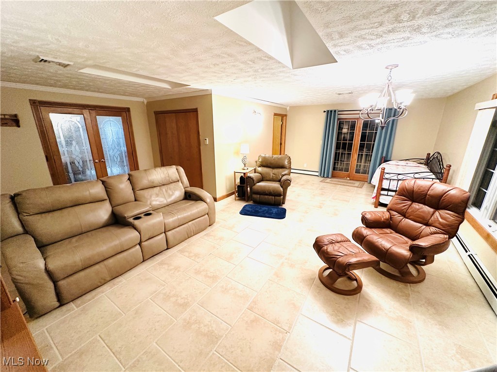 1684 Morris Street Mineral Ridge, OH 44440 - Photo 6 of 50 Living area with a textured ceiling, a chandelier, french doors, a baseboard radiator, and baseboards