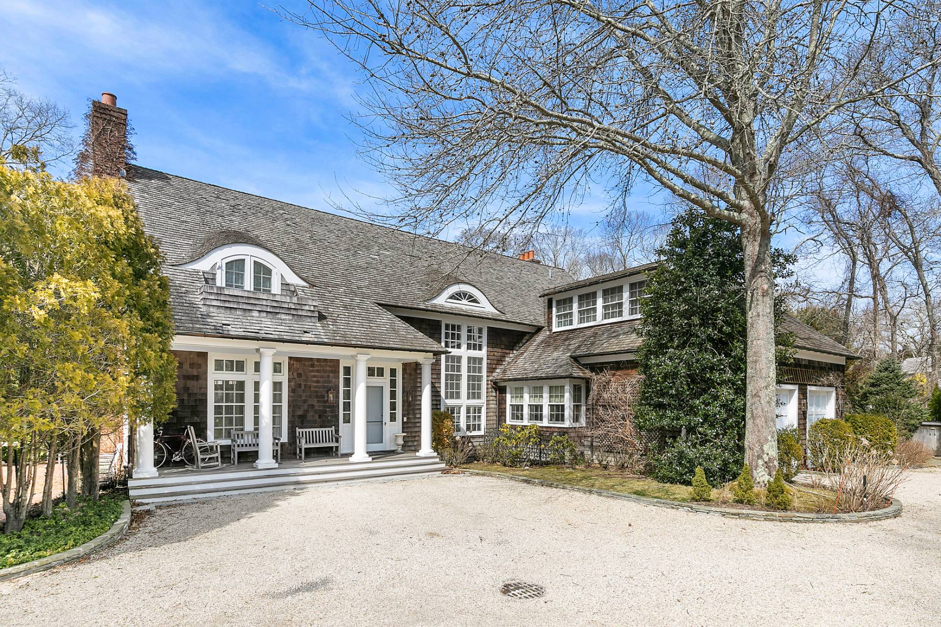 97 Briar Patch Road East Hampton, NY 11937 - Photo 12 of 12 a view of a brick house with large windows and a table and chairs