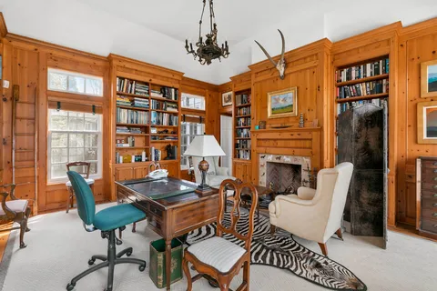 a work room with furniture a rug and a window