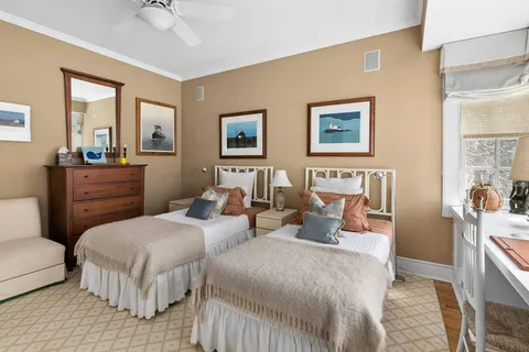 a bedroom with two beds and painting on the wall