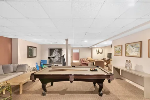 a living room with furniture a table and kitchen view