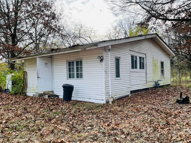 a backyard of a house with a large tree