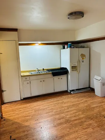 a view of a kitchen with wooden floor and a sink