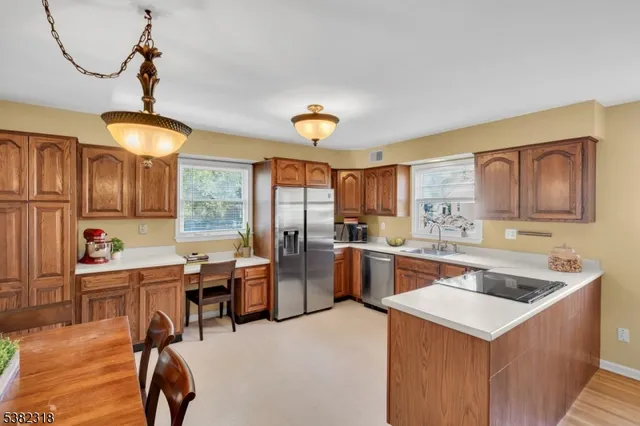 a kitchen that has a lot of cabinets in it and wooden floors