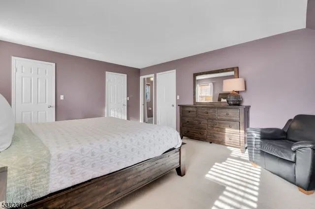 a spacious bedroom with a bed and dresser