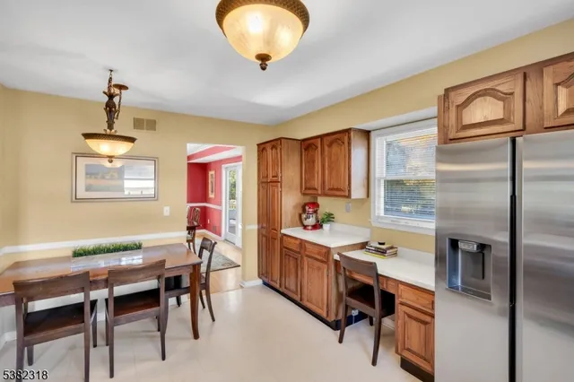 a kitchen with stainless steel appliances kitchen island granite countertop a table chairs in it and wooden floors