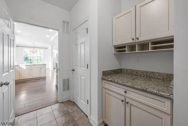 a kitchen with white cabinets and a window