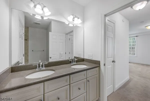 a bathroom with a granite countertop sink a light fixture and a mirror