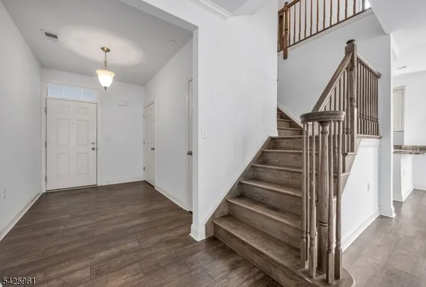 a view of entryway and hall with wooden floor