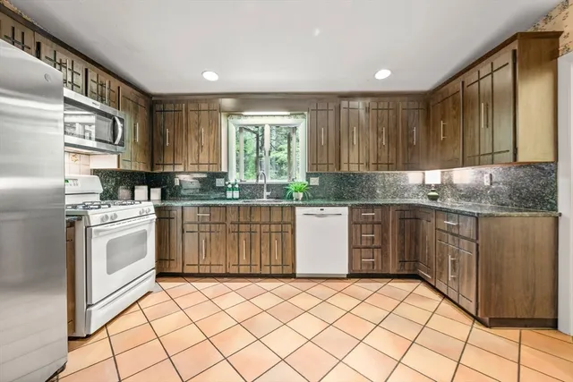 a kitchen with stainless steel appliances granite countertop a stove a sink dishwasher and a refrigerator