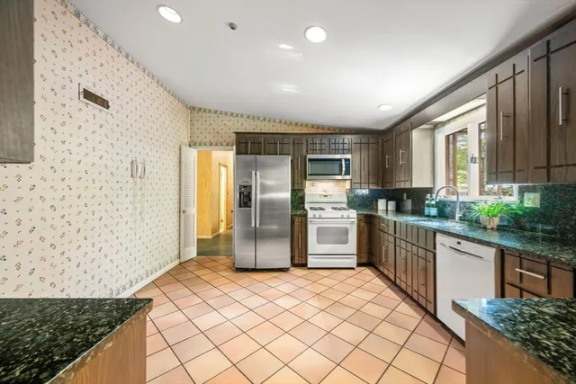 a kitchen with granite countertop a refrigerator and a sink
