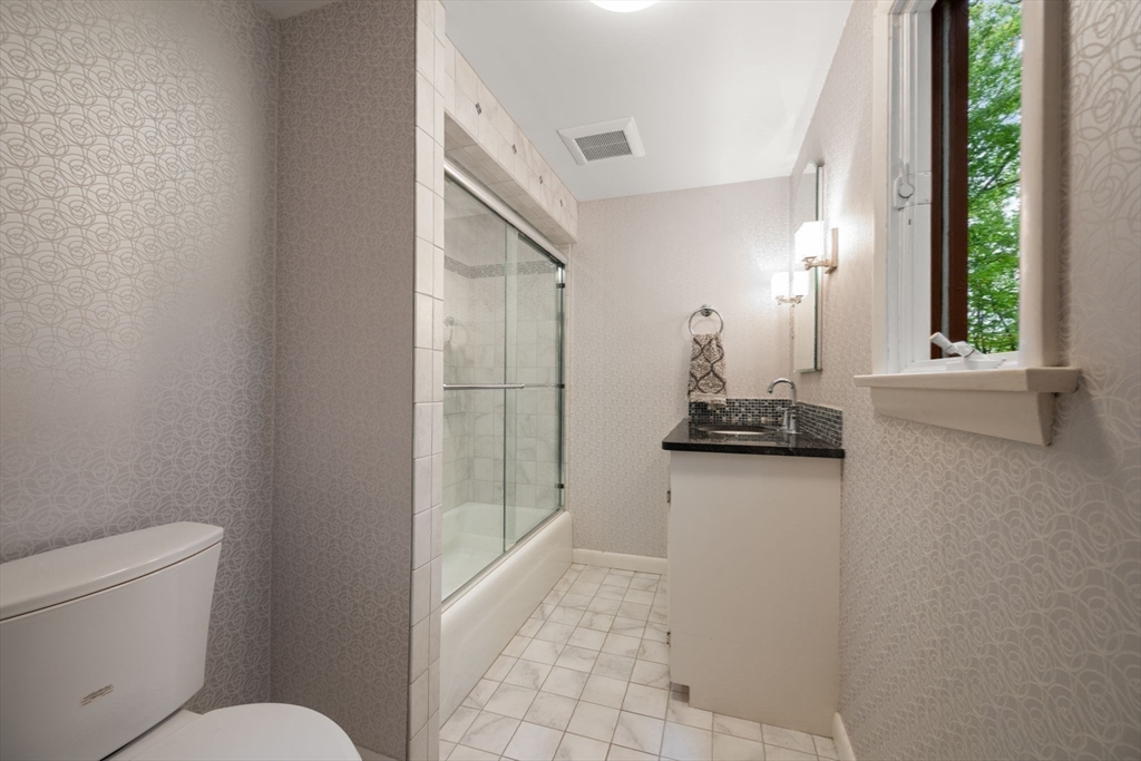 23 Indian Ridge Road Natick, MA 01760 - Photo 17 of 40 a bathroom with a granite countertop sink a toilet a mirror and window