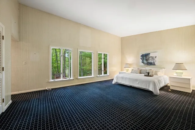 a bedroom with furniture and a large window