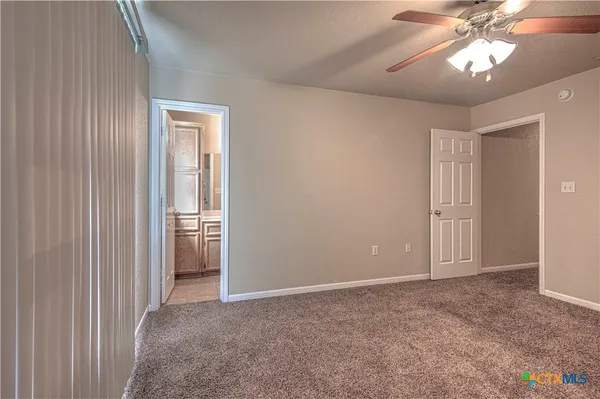 en empty room with windows and fan