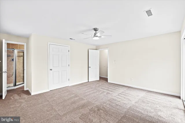 a view of an empty room with a ceiling fan