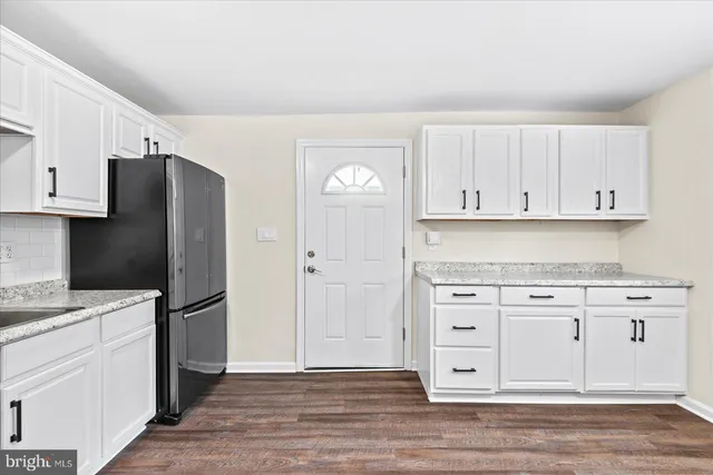 a kitchen with granite countertop white cabinets and stainless steel appliances