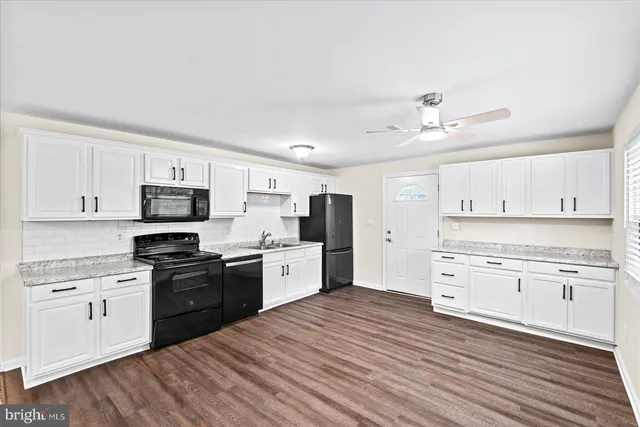 a kitchen with granite countertop white cabinets and stainless steel appliances