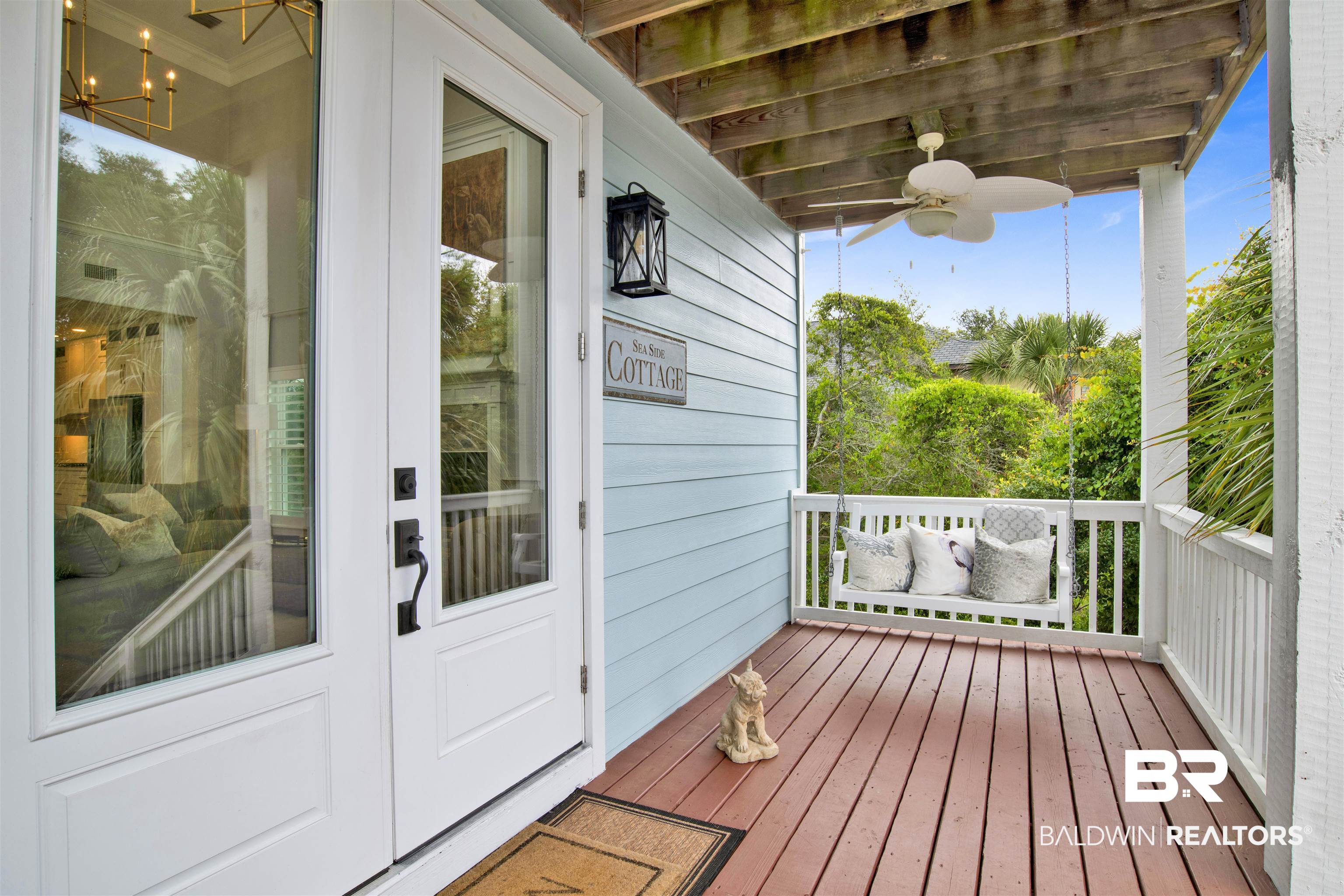 30351 River Road Orange Beach, AL 36561 - Photo 30 of 44 Inviting covered porch with a ceiling fan and a swing