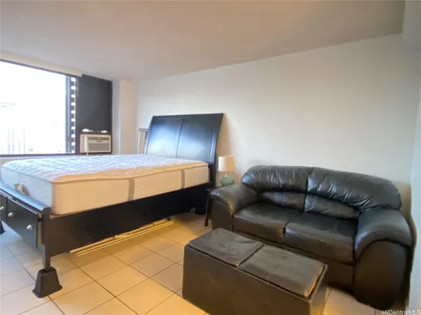 a bedroom with a bed couch and window