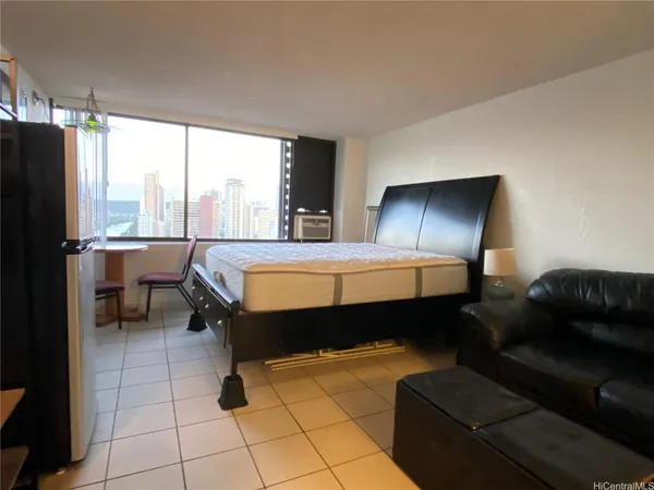 a bedroom with a bed and a couch next to a window