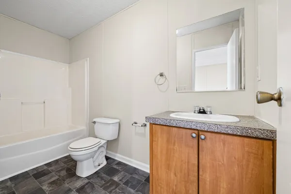 a view of an empty room with window and closet area