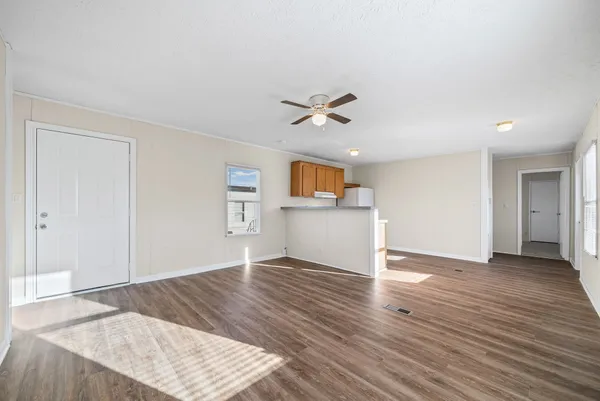 a kitchen with granite countertop wooden floors stainless steel appliances and a refrigerator