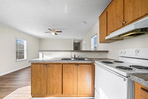 a view of a hallway with wooden floor and a bathroom