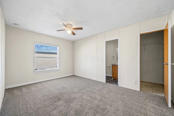 an empty room with closet and windows