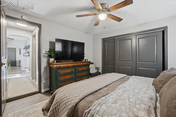a bedroom with a bed and a flat tv screen on dresser