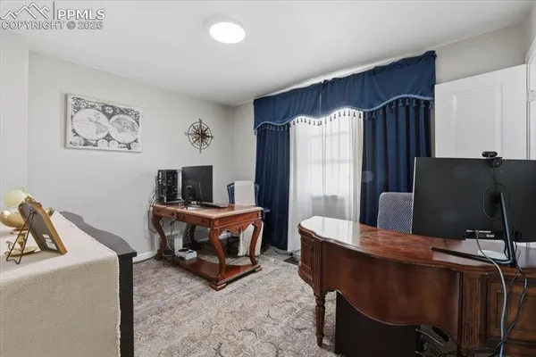 a living room with furniture a flat screen tv and a refrigerator