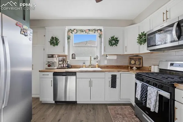 a kitchen with stainless steel appliances a sink cabinets and a window