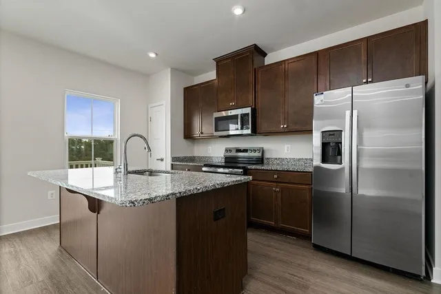 a kitchen with stainless steel appliances granite countertop a stove a sink and a refrigerator