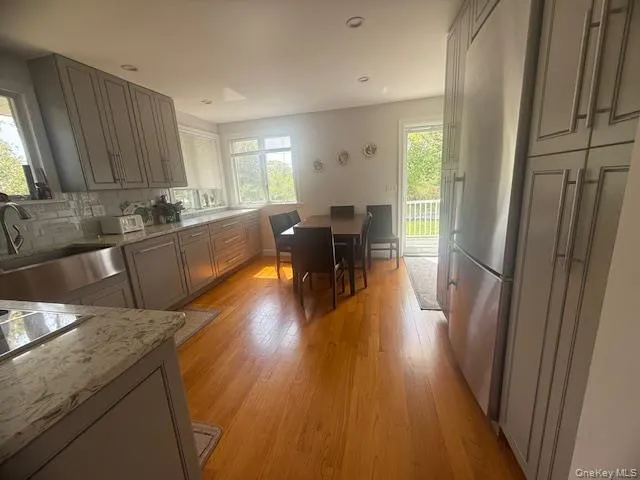 a kitchen with granite countertop sink refrigerator and wooden floor