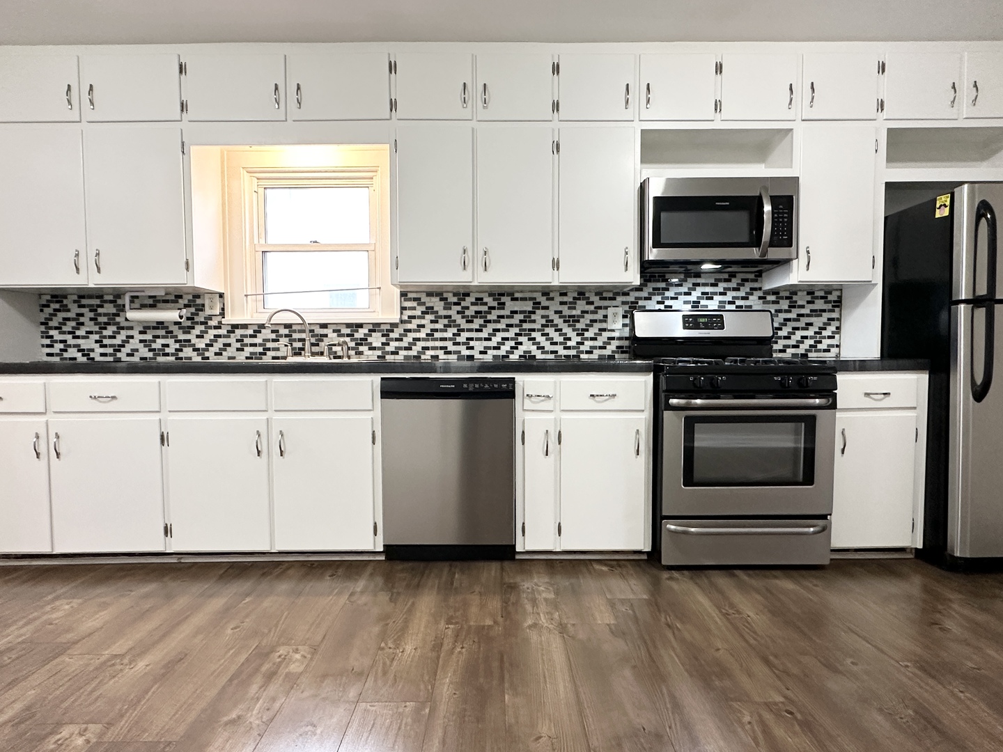 1075 South 7th Avenue Kankakee, IL 60901 - Photo 14 of 32 a kitchen with granite countertop a stove a sink and a microwave
