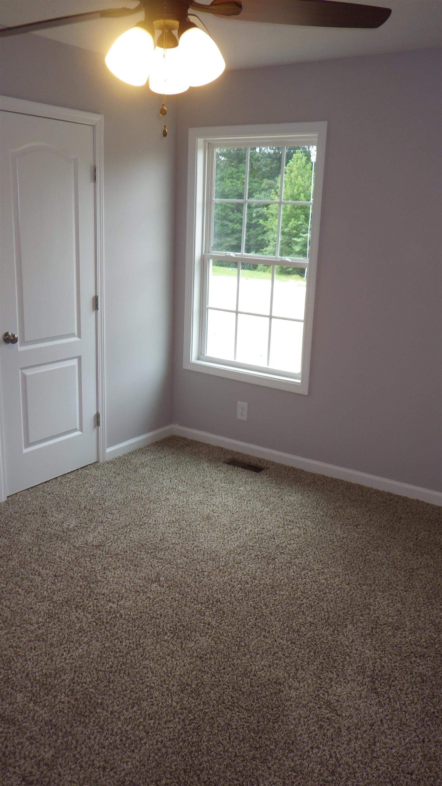 1211 East Ab Wade Road Portland, TN 37148 - Photo 11 of 30 an empty room with a chandelier fan and a window