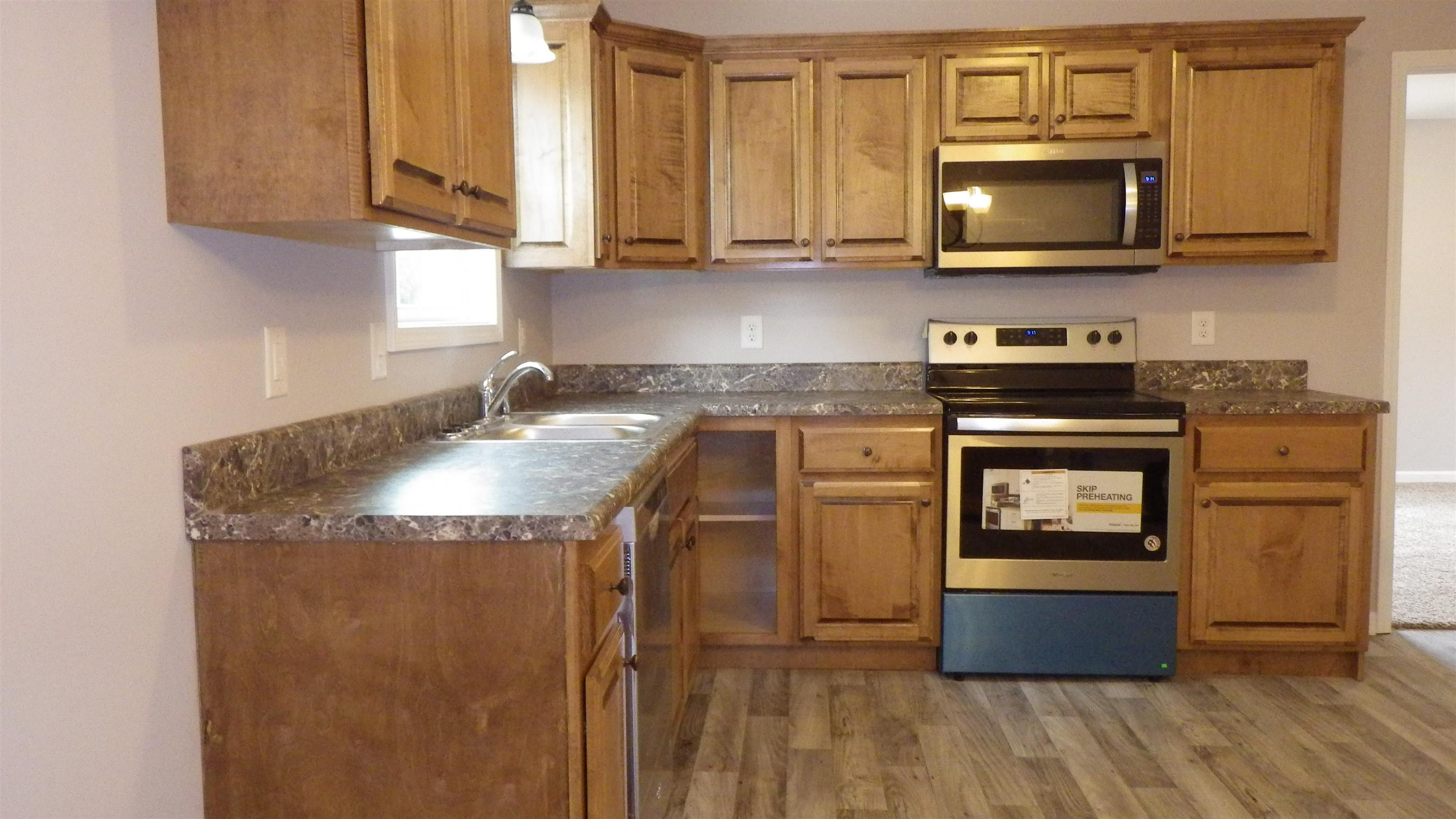 1211 East Ab Wade Road Portland, TN 37148 - Photo 18 of 30 a kitchen with granite countertop a stove a microwave a sink and cabinets