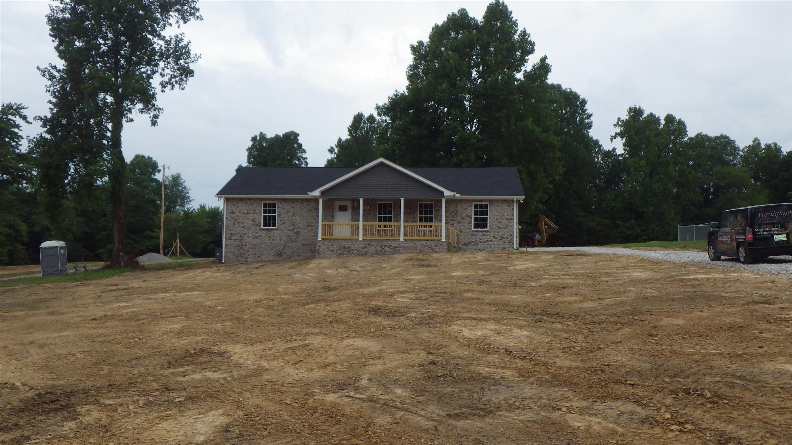 1211 East Ab Wade Road Portland, TN 37148 - Photo 3 of 30 a front view of a house with a garden and parking space