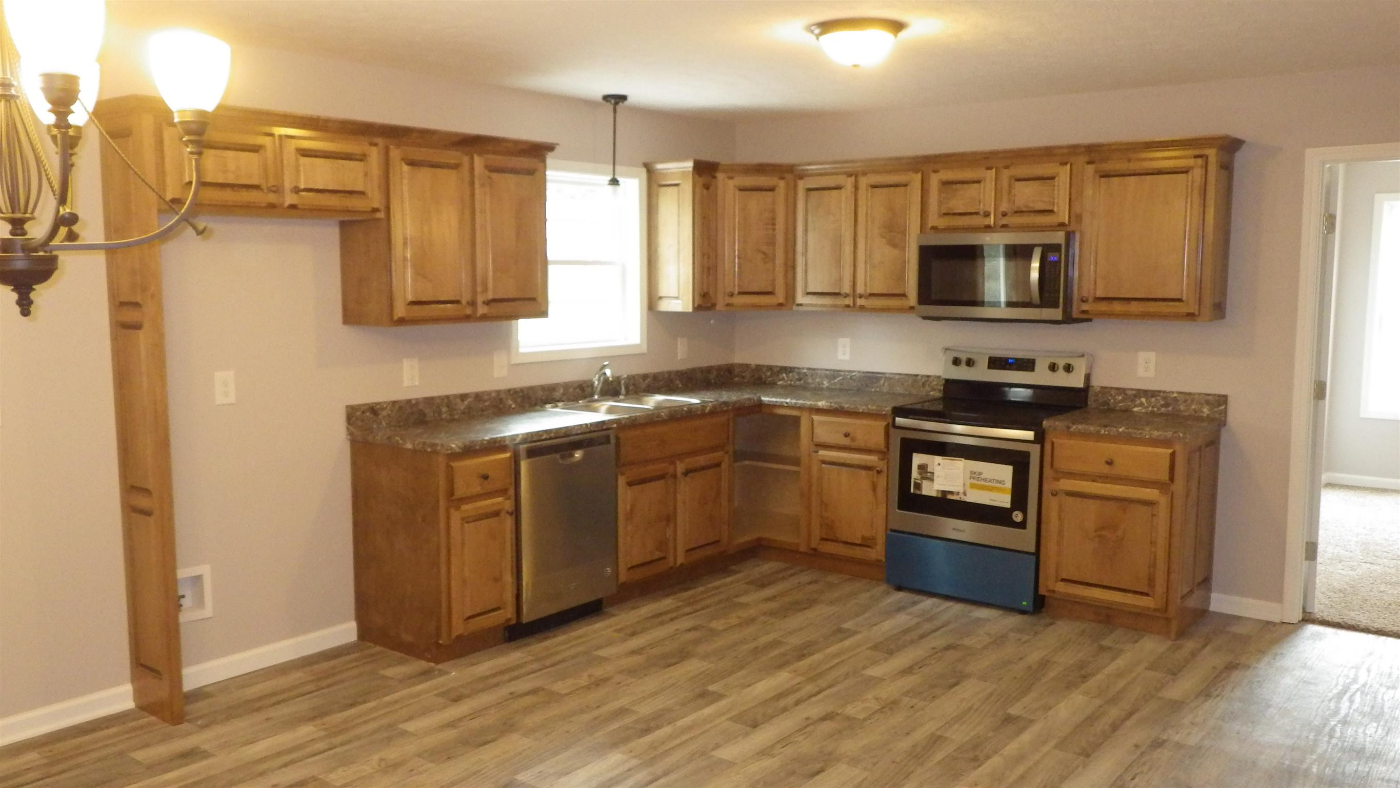 1211 East Ab Wade Road Portland, TN 37148 - Photo 22 of 30 a kitchen with stainless steel appliances granite countertop a stove a sink and a microwave