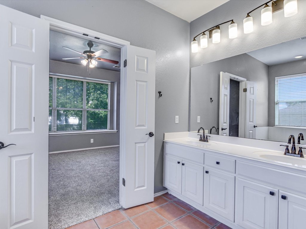 19910 Kennemer Drive Pflugerville, TX 78660 - Photo 11 of 21 a bathroom with a double vanity sink and a mirror