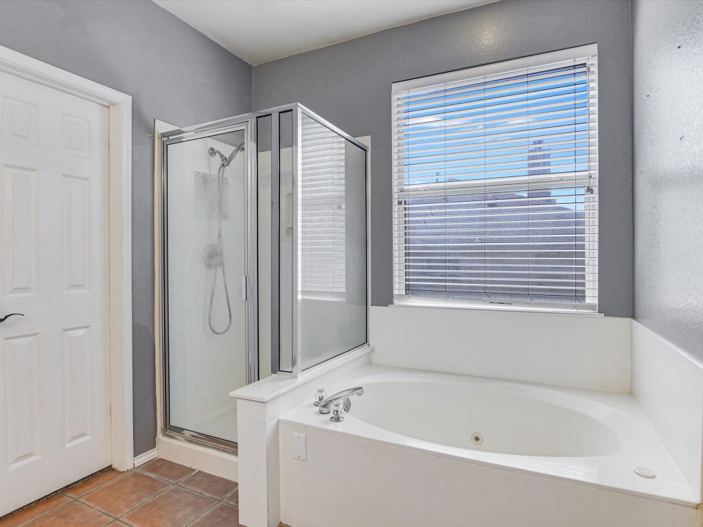 19910 Kennemer Drive Pflugerville, TX 78660 - Photo 12 of 21 a bathroom with a tub a sink and a mirror