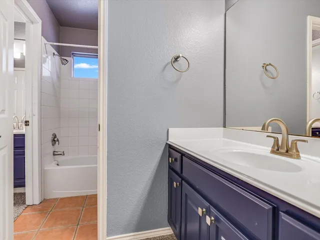 a bathroom with a granite countertop sink a mirror and shower