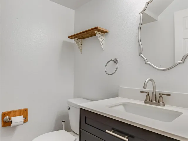 a bathroom with a sink mirror vanity and toilet