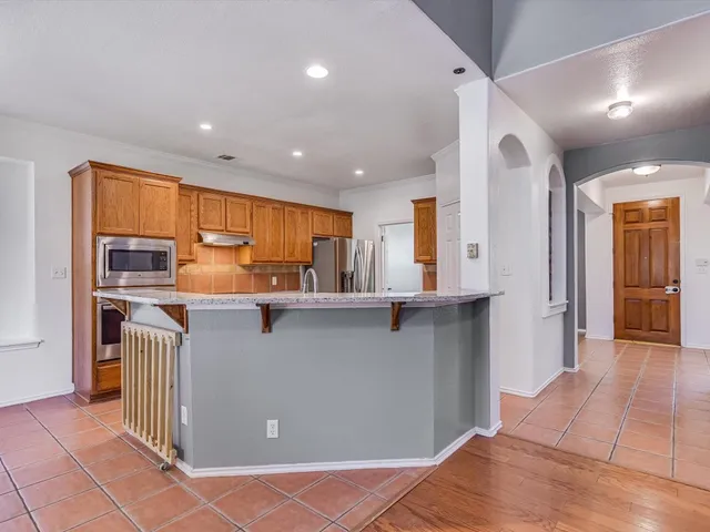 a kitchen with stainless steel appliances granite countertop a refrigerator and a sink