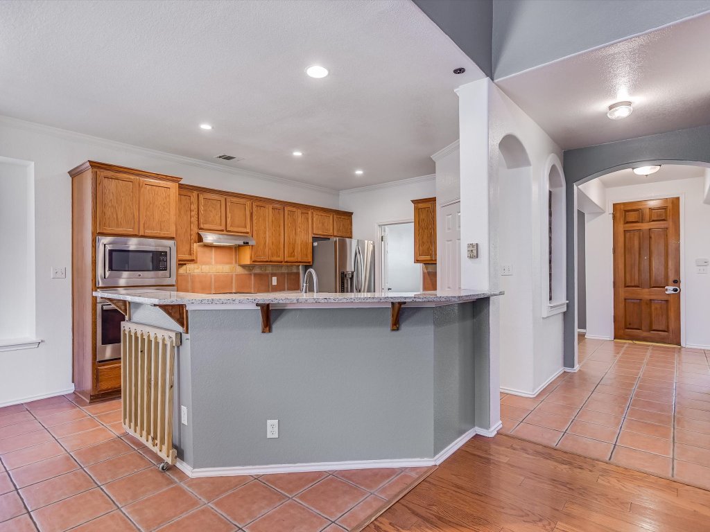 19910 Kennemer Drive Pflugerville, TX 78660 - Photo 4 of 21 a kitchen with stainless steel appliances granite countertop a refrigerator and a sink