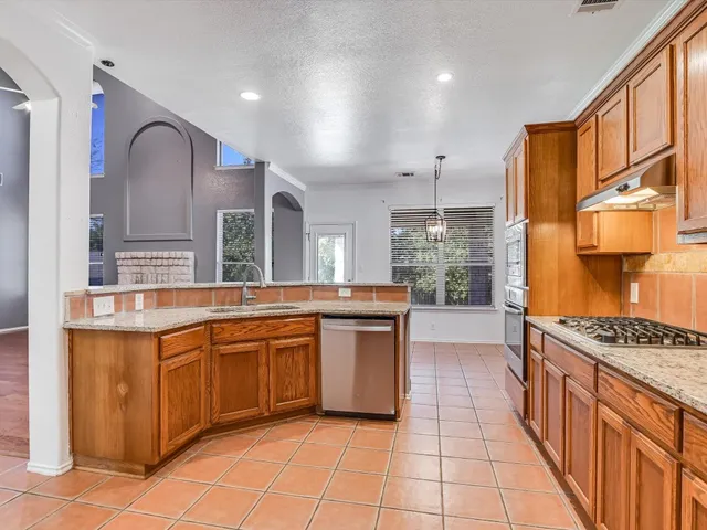 a kitchen with stainless steel appliances granite countertop a sink and cabinets