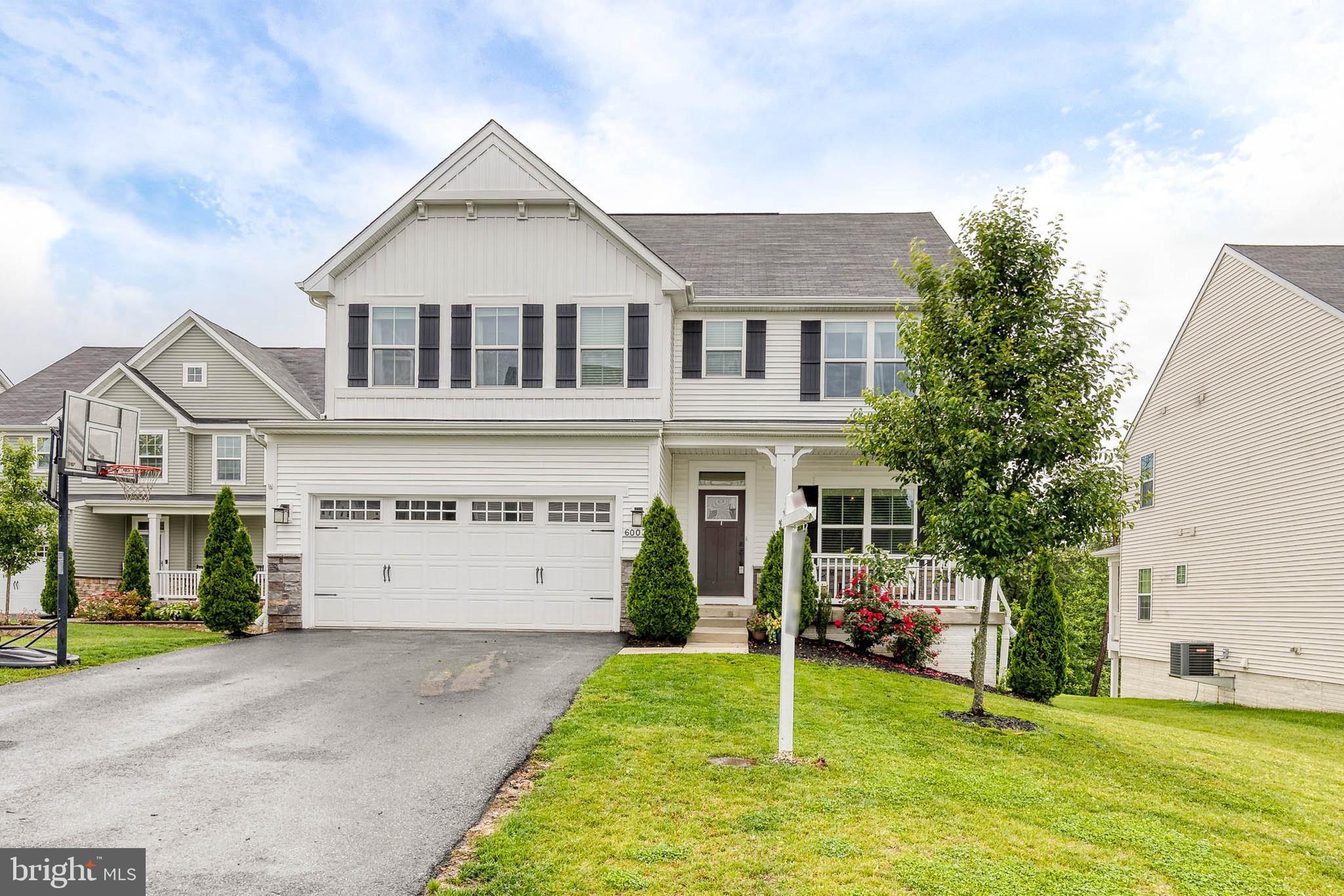 6003 Valentine Way Hanover, MD 21076 - Photo 2 of 52 a view of a white house with a big yard and potted plants